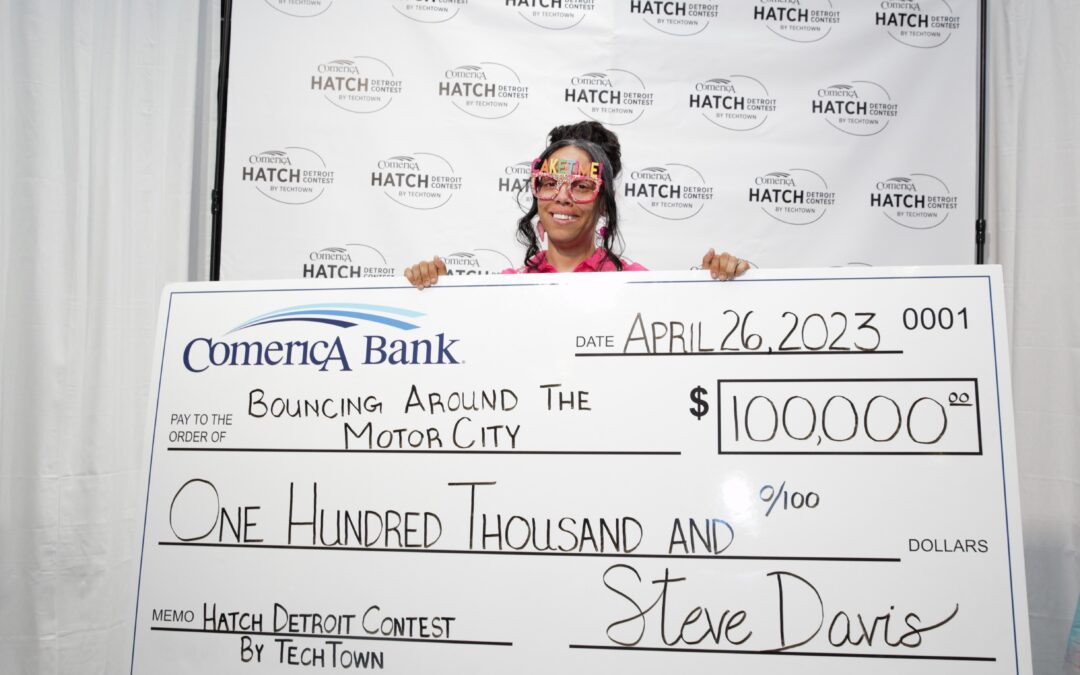 Bouncing Around The Motor City owner holding a large check for $100,000