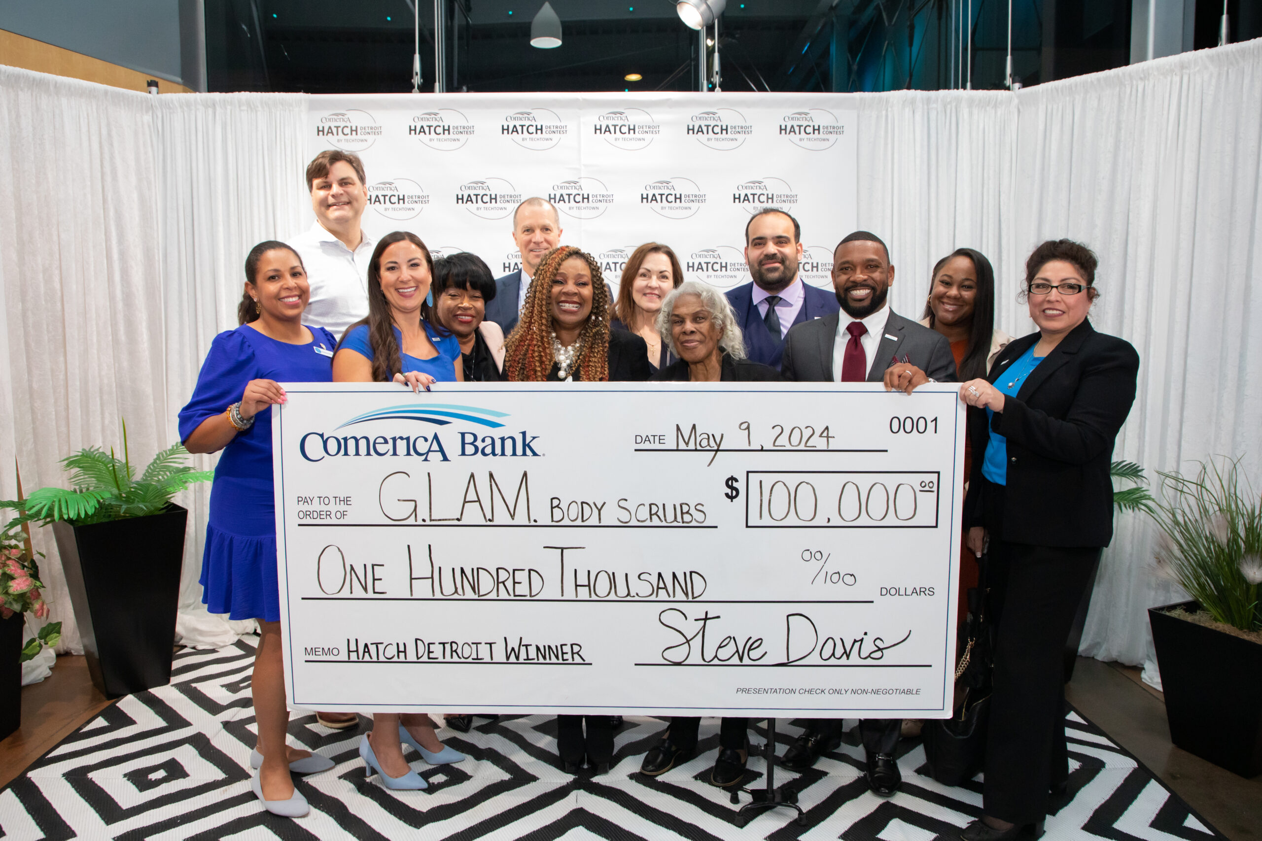 2024 Comerica Hatch Winner G.L.A.M. with giant check and sponsors. 